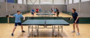 Een jonge speler slaat een backhand aan de tafeltennistafel