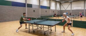 Twee spelers in een rally aan een tafeltennistafel, de bal boven het net
